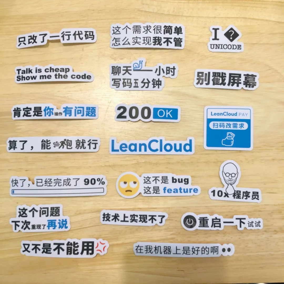 摆放在木桌上的 19 枚新版程序员贴纸